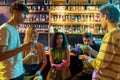 Attractive young women drinking cocktail at the bar counter and chatting with men they just met. Young adults having Royalty Free Stock Photo