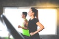 Attractive young woman and female running on treadmill machine at gym sports club. Fitness Healthy lifestye and workout at gym