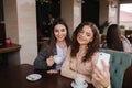 Attractive young women making selfie in restairant. Women drin cappuccino on terrace. Two female make photo together Royalty Free Stock Photo