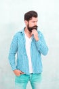 Attractiveness concept. Well groomed guy. Brutal handsome hipster man grey wall background. Bearded man trendy hipster