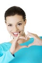 Attractiveyoung woman showing heart gesture