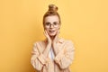 Attrctive stylish female student holding palms on her cheeks Royalty Free Stock Photo