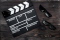 Attributes of film director. Movie clapperboard and sunglasses on wooden table background top view