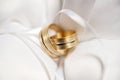 Attributes of the wedding, wedding rings of yellow metal on a white pillow. Royalty Free Stock Photo