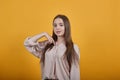 Atttractive woman in pastel shirt pointing fingers at herself, looking at camera