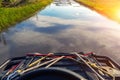 ATV quadbike riding through flooded after heavy storm rain road with scenic clear blue cloud sky reflection in water pudle. Royalty Free Stock Photo