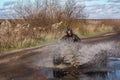 ATV race, dirty road. Uncnown driver in water and mud Royalty Free Stock Photo