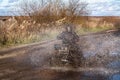 ATV race, dirty road. Uncnown driver in water and mud Royalty Free Stock Photo