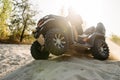 Atv rider in helmet climbing sandy road in forest Royalty Free Stock Photo