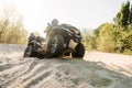 Atv rider in helmet climbing sandy road in forest Royalty Free Stock Photo