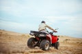 An atv rider racing in desert