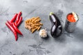 Aubergine penne ingredients eggplant pasta, pepper tomatoe sauce, on grey background side view Royalty Free Stock Photo