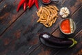 Aubergine penne ingredients eggplant pasta, pepper tomatoe sauce, on old dark wooden table top view space for text Royalty Free Stock Photo