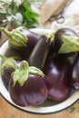 Aubergines in a bowl on a wooden table. Vertical. Royalty Free Stock Photo