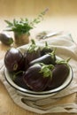 Aubergines in a bowl on a wooden table. Vertical. Royalty Free Stock Photo