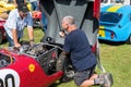 people looking inside open bonnet of red sports car Royalty Free Stock Photo