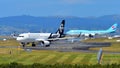 Air New Zealand Airbus A320 taxiing with Korean Air Boeing 747-8i in the background at Auckland International Airport