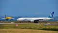 Air New Zealand Boeing 777-200ER taxiing as DHL Tasman Cargo Airlines Boeing 757 freighter lands