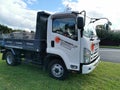 AUCKLAND, NEW ZEALAND - Sep 24, 2020: View of Sunset Concrete Isuzu N Series truck packed on green lawn