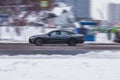 Audi A7 on the city road. Gray car with man driving on winter streets. Second generation auto in fast motion with blurred Royalty Free Stock Photo