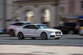 Audi A5 Coupe on the road in motion. Fast speed drive on city road. Front side view of moving white car on the street Royalty Free Stock Photo