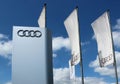 Audi logo and flags in the car dealership of the area, against a blue sky