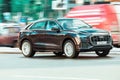 Audi Q8 car driving in city with motion blur, front side view. Brown premium SUV in fast motion on street Royalty Free Stock Photo