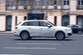 Audi Q7 car in motion blur on speedway road, panning shot taken from the side. White SUV driving on the motorway