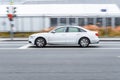 Audi A6 rolling shot down the street on high speed. White sedan car rushes on urban road, side view Royalty Free Stock Photo