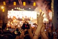 Audience with hands raised at a music festival and lights streaming down from above the stage Royalty Free Stock Photo