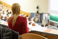 Audience in the lecture hall. Female student making notes. Royalty Free Stock Photo