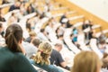 Audience in the lecture hall. Female student making notes. Royalty Free Stock Photo