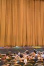 Audience in Theater. closed stage curtain in a theater. blurry. vertical photo