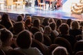 The audience in the theater watching a play. The audience in the hall: adults and children Royalty Free Stock Photo