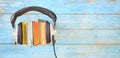 Audio book concept, with row of books, headphones,