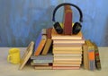 Audio book concept, with stack of books, headphones and cup of coffee Royalty Free Stock Photo