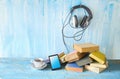 Audio book concept, with stack of books, headphones, smartphone and cup of coffee Royalty Free Stock Photo