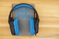 Audio books message with blue and black headset with microphone with a book Royalty Free Stock Photo