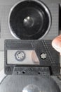 Audio cassette in the hands against the background of the acoustic system.