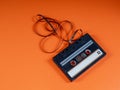 Audio cassette, musicassette with tape draped artistically. Music concept, sounds of youth on seventies style orange