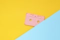 Audio cassette on a pastel-colored paper background. Retro media technology 80s. Music, entertainment. Top view. minimalism trend. Royalty Free Stock Photo