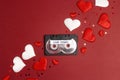 Audio cassette tape with love songs and hearts on red background. Romantic mood music concept