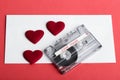 Audio cassette tape on red backgound with fabric heart Royalty Free Stock Photo