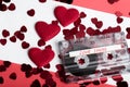 Audio cassette tape on red backgound with fabric heart