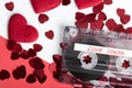 Audio cassette tape on red backgound with fabric heart Royalty Free Stock Photo