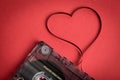 Audio cassette tape on red backgound. Film shaping heart Royalty Free Stock Photo