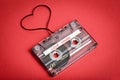 Audio cassette tape on red backgound. Film shaping heart Royalty Free Stock Photo