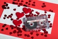 Audio cassette tape on red background with fabric heart