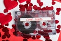 Audio cassette tape on red background with fabric heart