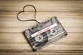 Audio cassette tape on wooden backgound. Film shaping heart Royalty Free Stock Photo